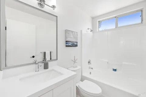 a bathroom with a sink toilet vanity and shower