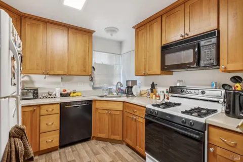a kitchen with a sink stove top oven and cabinets