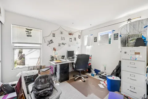 a view of a workspace with furniture and a window