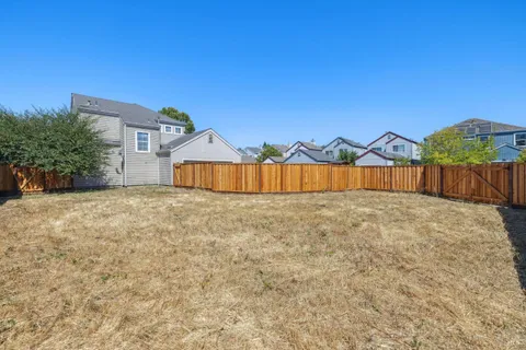 a view of a house with a yard and large tree