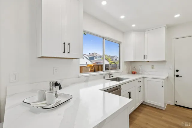 a kitchen with granite countertop white cabinets and white appliances