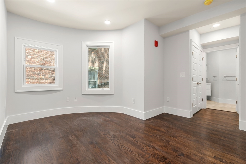 111 Winthrop Road, Unit 2 Brookline, MA 02445 - Photo 6 of 12 a view of an empty room with wooden floor and a window