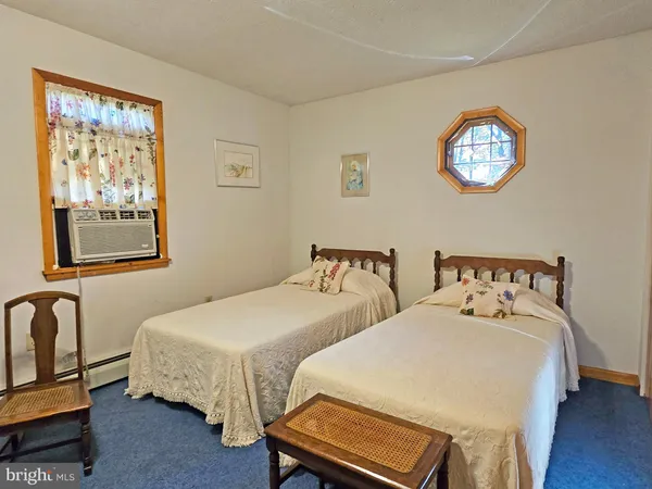 a bedroom with two beds and a lamp on table