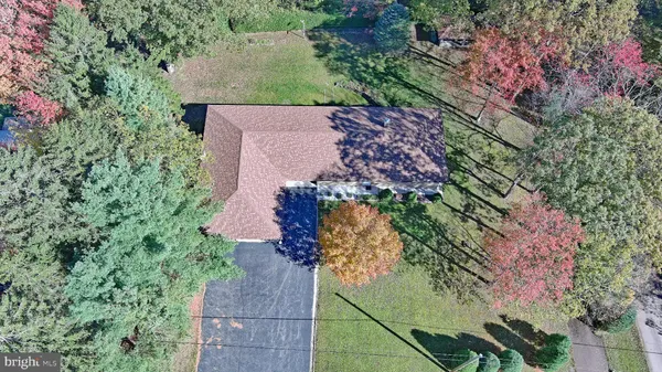 a front view of a house with a garden and trees