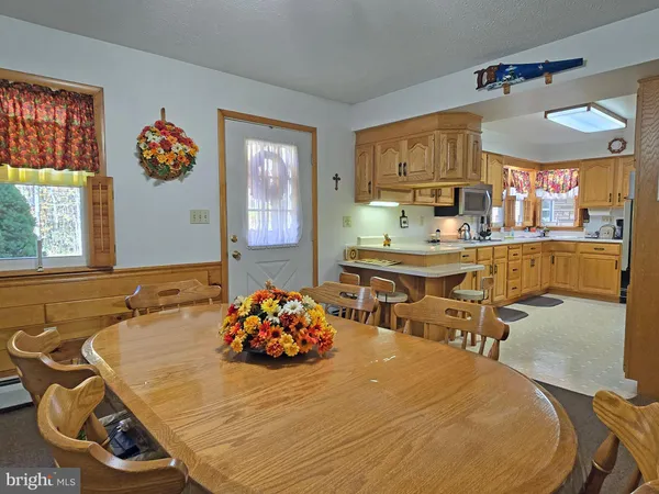 a room with a table chairs and window