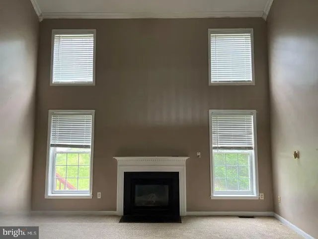 a view of an empty room with a window and fire place