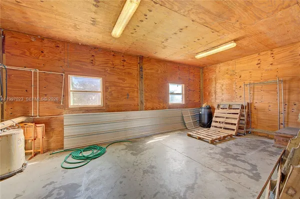 a living room with furniture and a refrigerator
