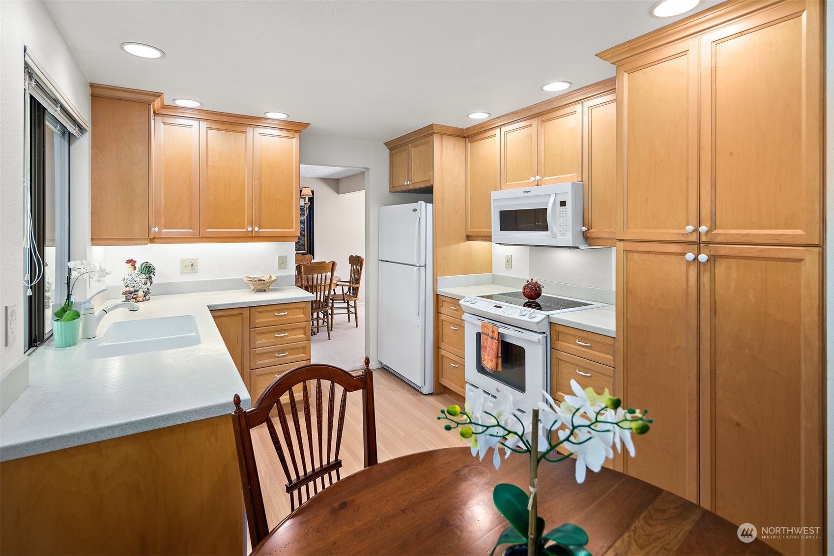175 Mt Si Place Northwest Issaquah, WA 98027 - Photo 10 of 35 a kitchen with stainless steel appliances a microwave a stove a sink dishwasher and a dining table with wooden floor