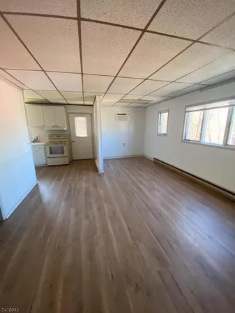 a view of a room with wooden floors and windows