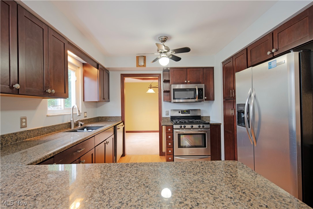 2501 East Pleasant Valley Road Independence, OH 44131 - Photo 11 of 29 Kitchen featuring sink, ceiling fan, stainless steel appliances, and light granite counters