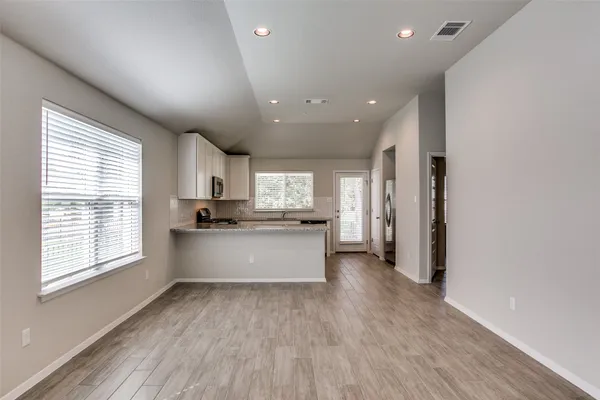 a large kitchen with stainless steel appliances granite countertop a large counter top a sink and a refrigerator