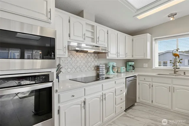 a kitchen with white cabinets and appliances