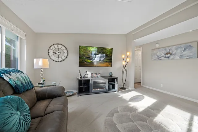 a living room with furniture a window and a clock