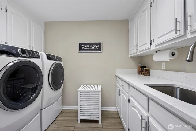 a utility room with sink dryer and washer