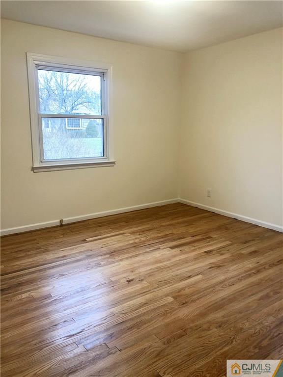 27 Forrest Street Iselin, NJ 08830 - Photo 12 of 12 an empty room with wooden floor and windows