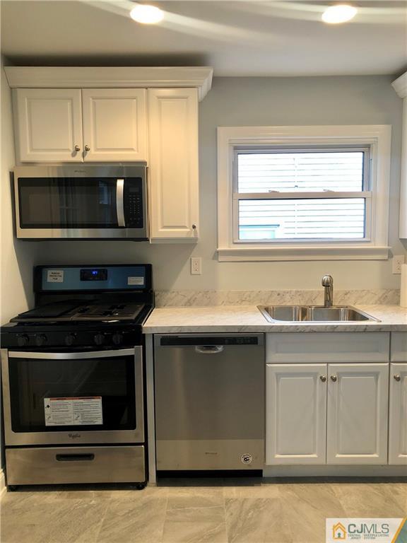 27 Forrest Street Iselin, NJ 08830 - Photo 3 of 12 a kitchen with granite countertop a stove microwave and sink