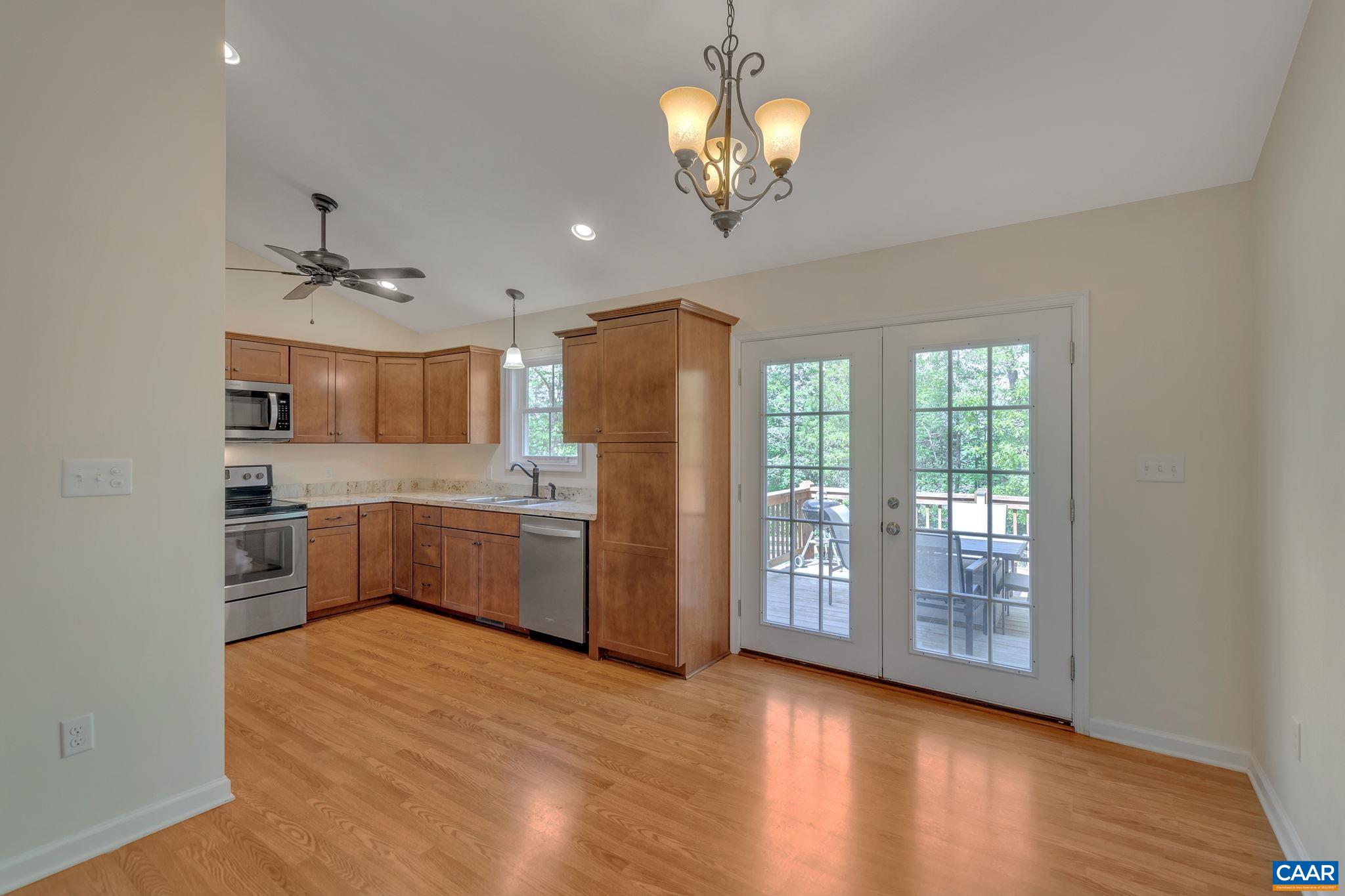 171 Goldenrod Road Ruckersville, VA 22968 - Photo 18 of 45 a kitchen with stainless steel appliances granite countertop a refrigerator a sink dishwasher a stove and a dining table with wooden floor