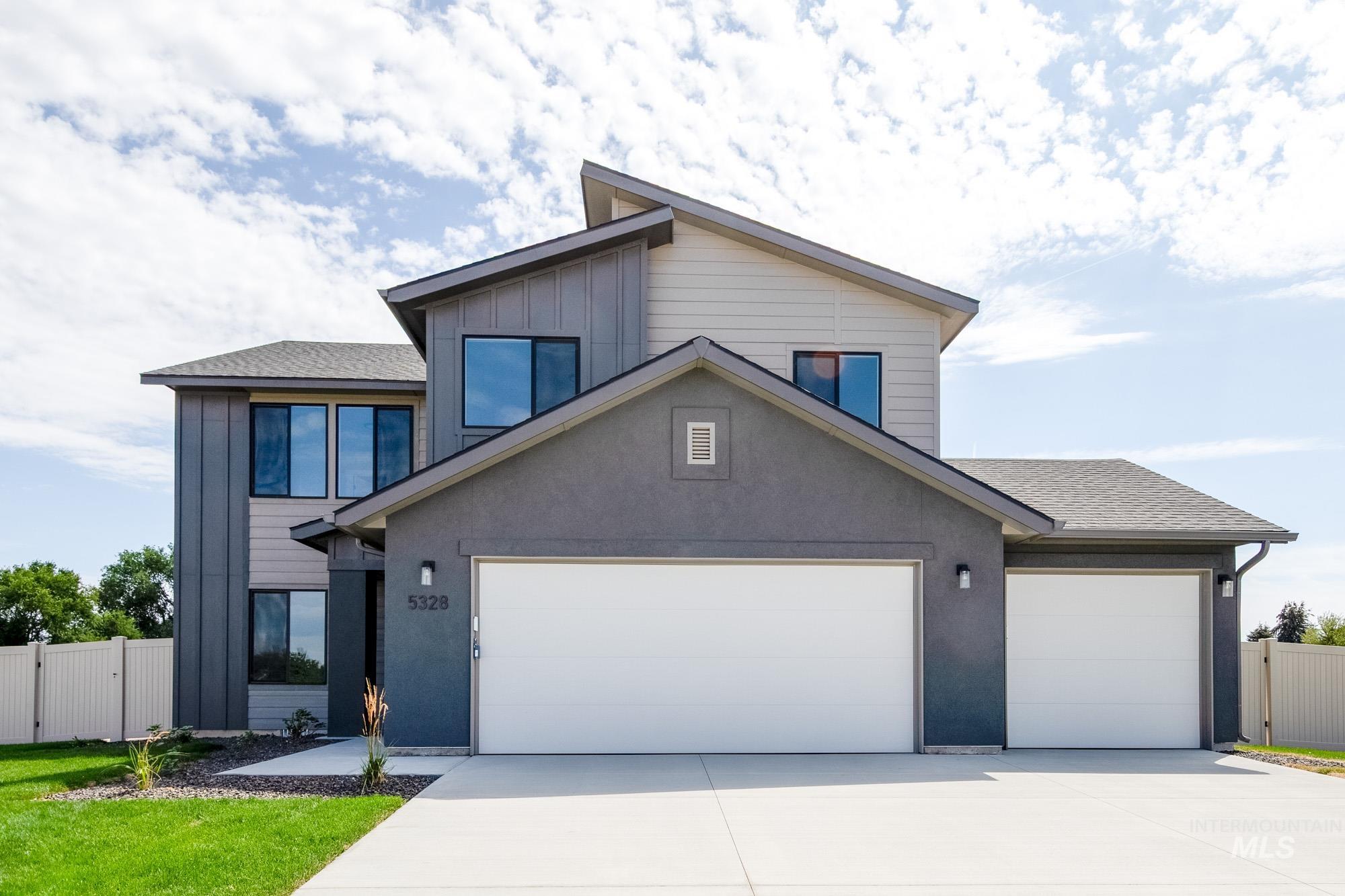 View of front of property featuring concrete driveway, a garage, roof with shingles, and board and batten siding