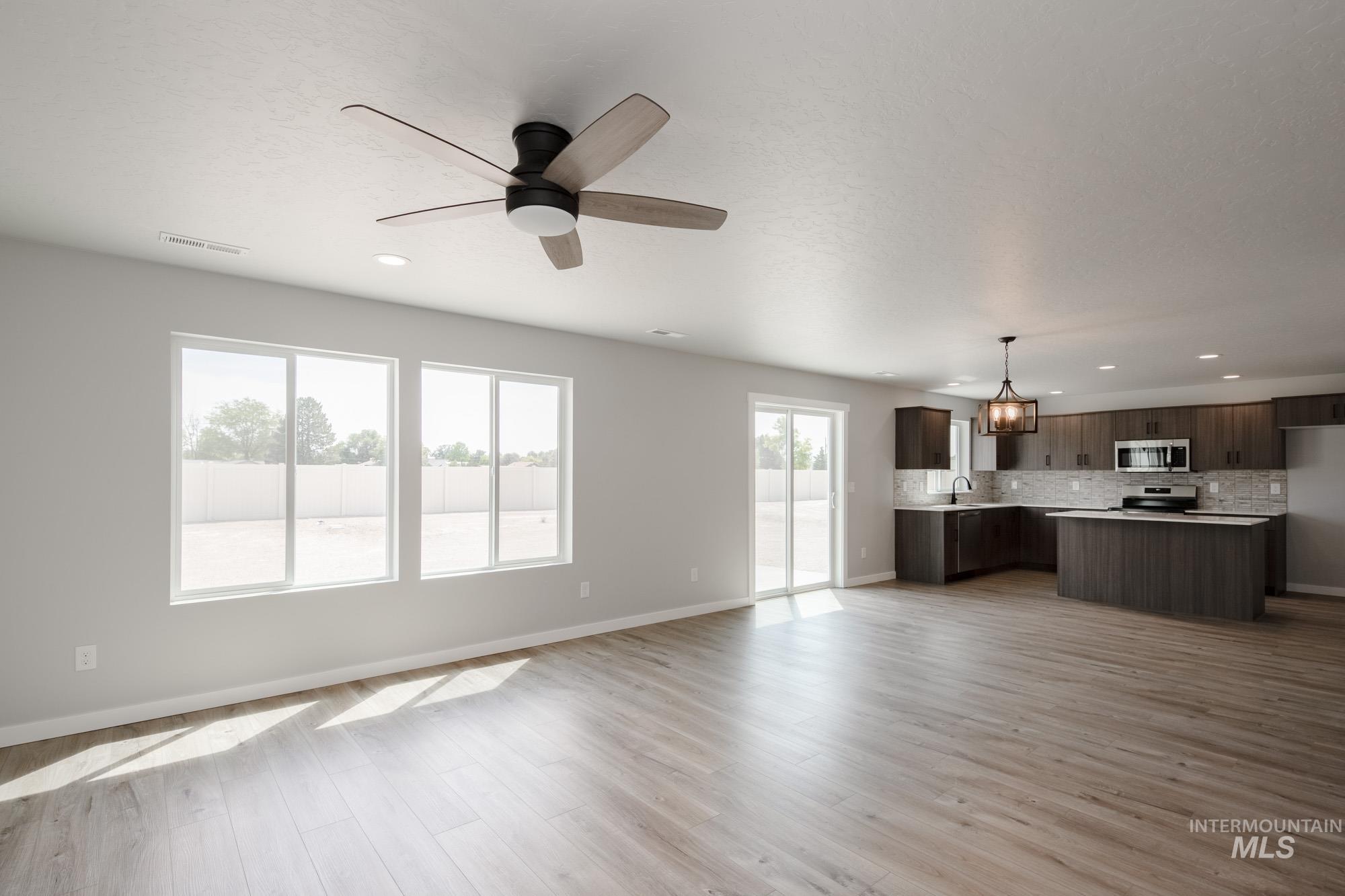 5328 Castleton Avenue Nampa, ID 83686 - Photo 12 of 26 Unfurnished living room featuring light wood-style flooring, a ceiling fan, and recessed lighting