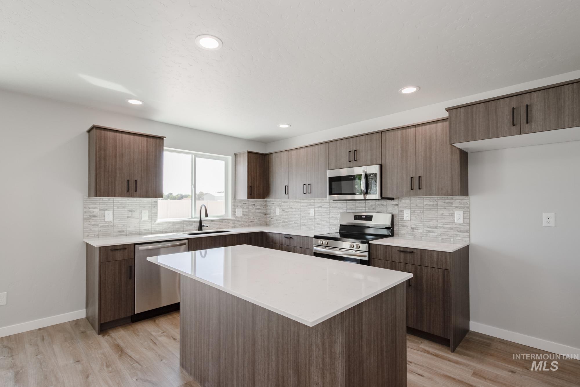 5328 Castleton Avenue Nampa, ID 83686 - Photo 4 of 26 Kitchen featuring tasteful backsplash, stainless steel appliances, light wood-type flooring, light countertops, and recessed lighting