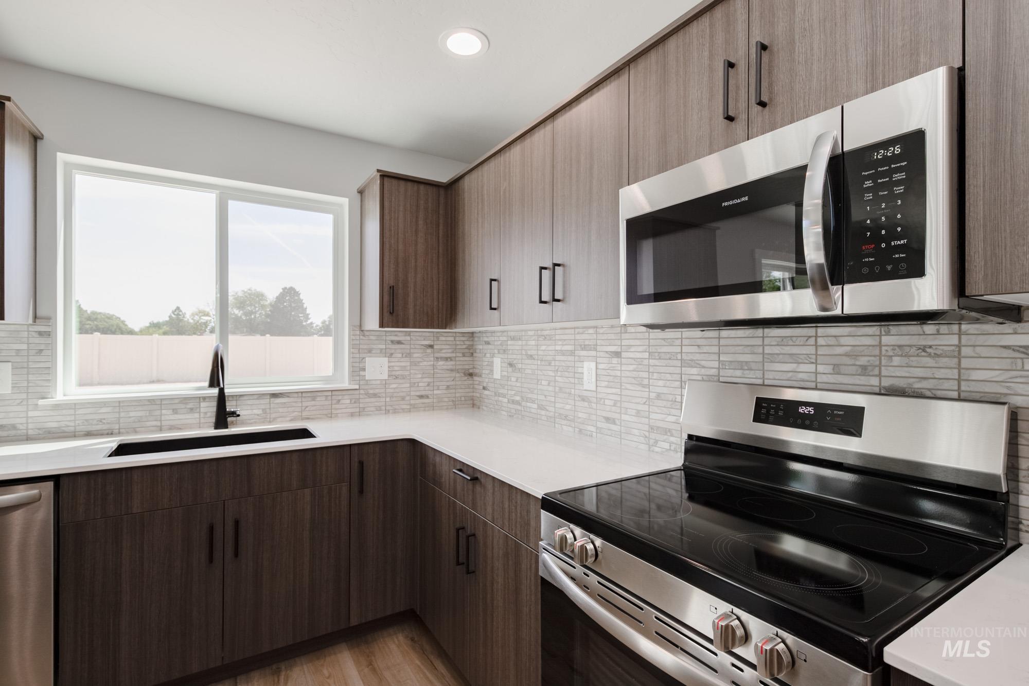 5328 Castleton Avenue Nampa, ID 83686 - Photo 7 of 26 Kitchen with stainless steel appliances, tasteful backsplash, light countertops, light wood-style floors, and recessed lighting