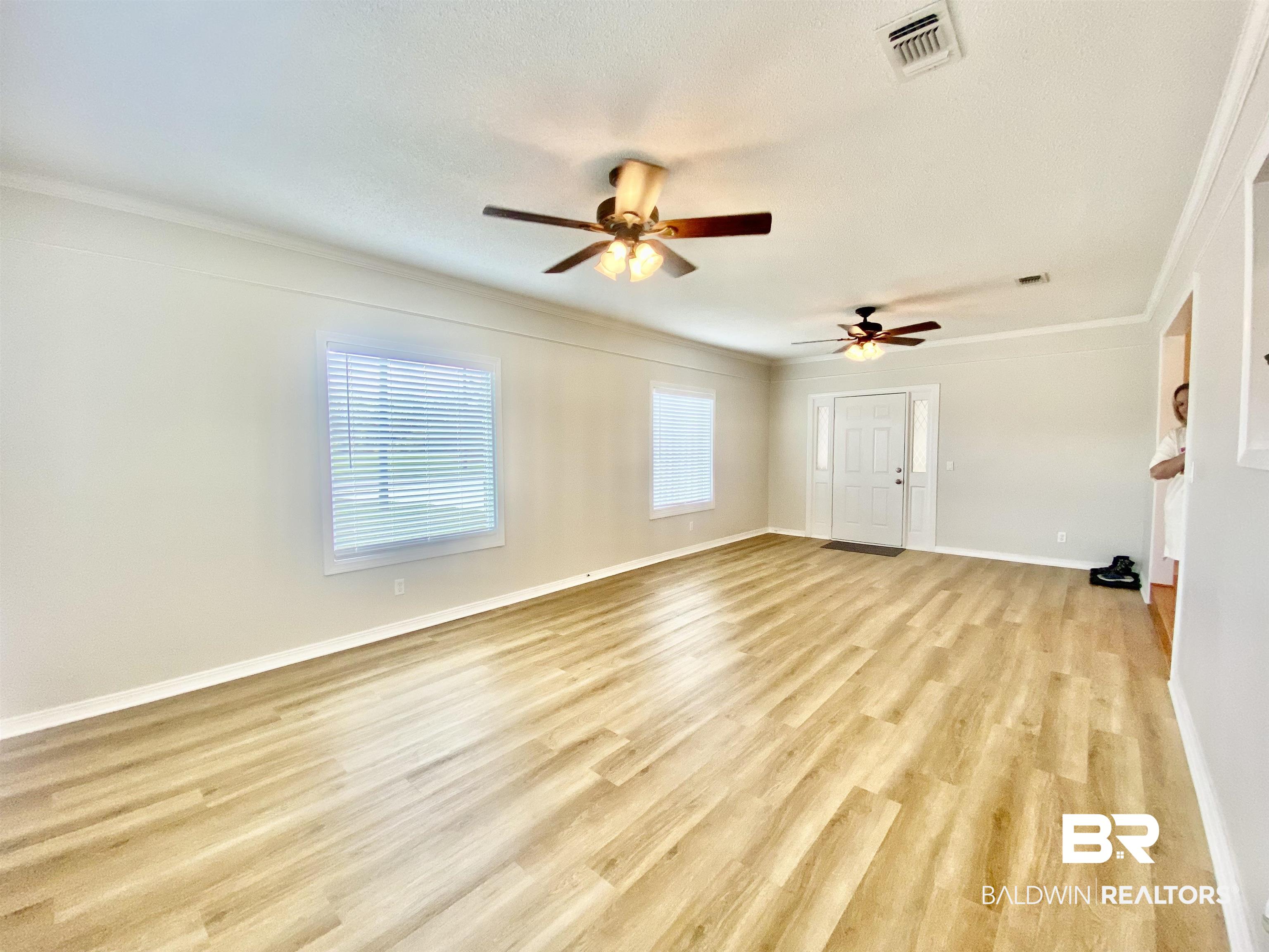 265 Azalea Drive Monroeville, AL 36460 - Photo 15 of 39 Unfurnished room with ornamental molding, a textured ceiling, ceiling fan, and light hardwood / wood-style flooring