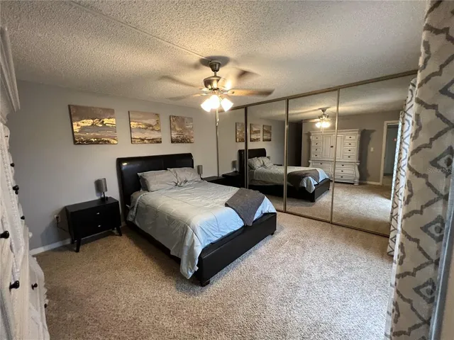 a bedroom with a bed couch and a ceiling fan