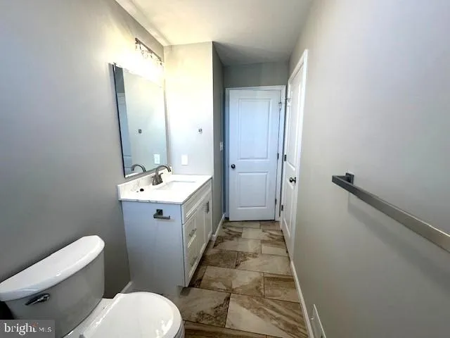 a bathroom with a sink mirror vanity and toilet