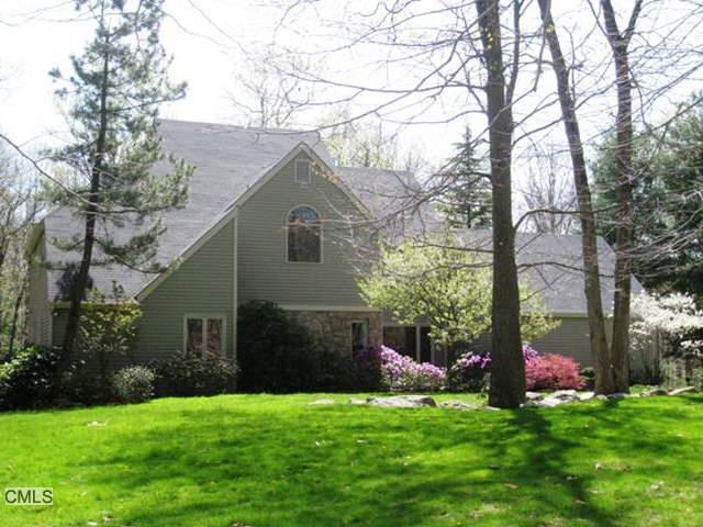 a front view of a house with a garden and trees