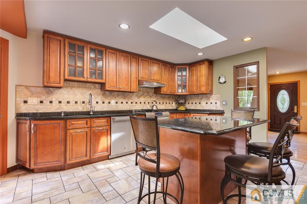 5 Herron Road Edison, NJ 08820 - Photo 14 of 42 a kitchen with granite countertop sink cabinets and stainless steel appliances