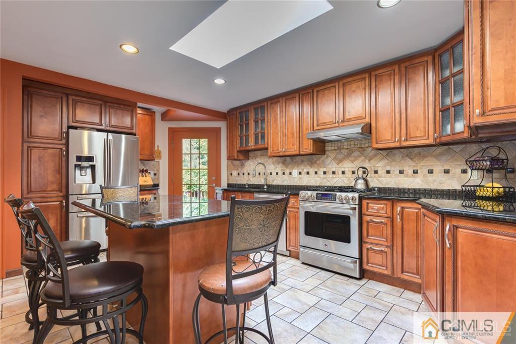 5 Herron Road Edison, NJ 08820 - Photo 15 of 42 a kitchen with stainless steel appliances granite countertop a stove top oven a sink dishwasher and cabinets with wooden floor
