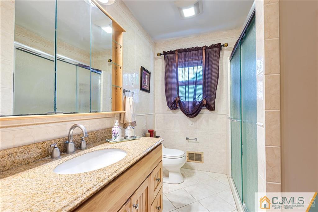 5 Herron Road Edison, NJ 08820 - Photo 24 of 42 a bathroom with a granite countertop toilet sink and mirror