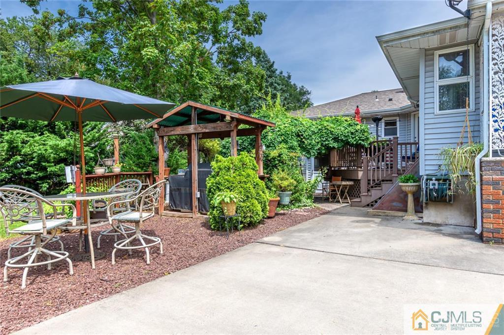 5 Herron Road Edison, NJ 08820 - Photo 35 of 42 a view of patio with chairs and table under an umbrella