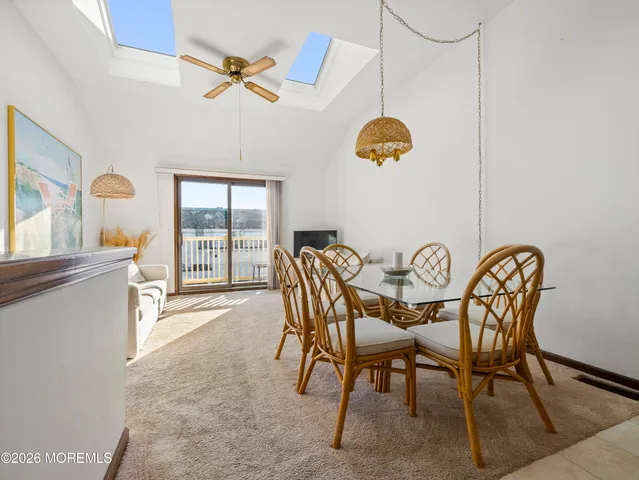 a kitchen with stainless steel appliances granite countertop a sink a stove a refrigerator cabinets and a dining table