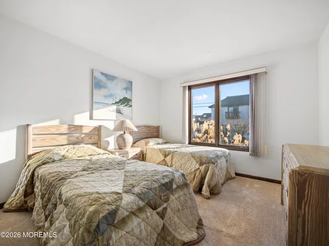 a spacious bedroom with a bed a couch and large window