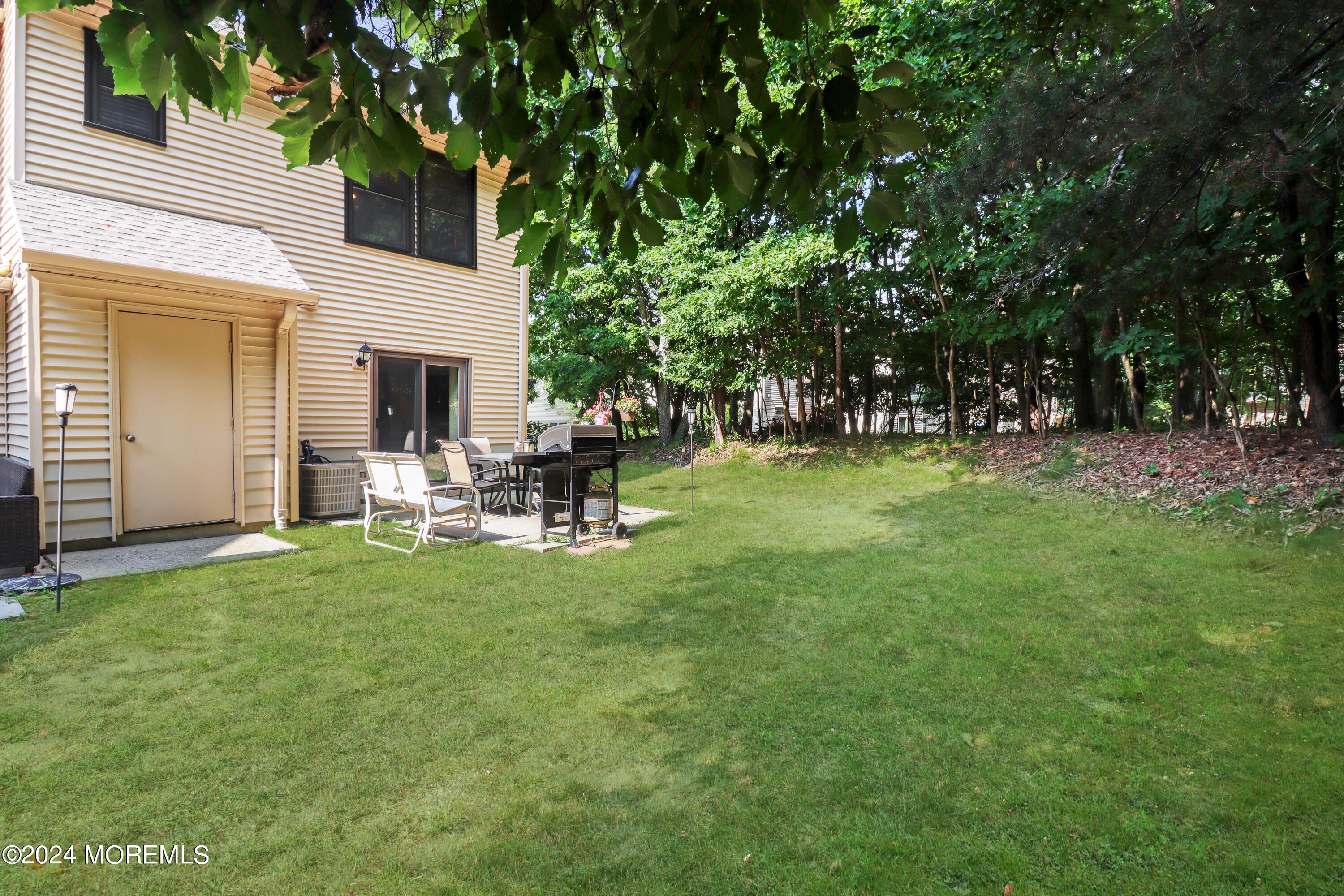 100 Whispering Oaks Way Jackson, NJ 08527 - Photo 11 of 56 a backyard of a house with table and chairs