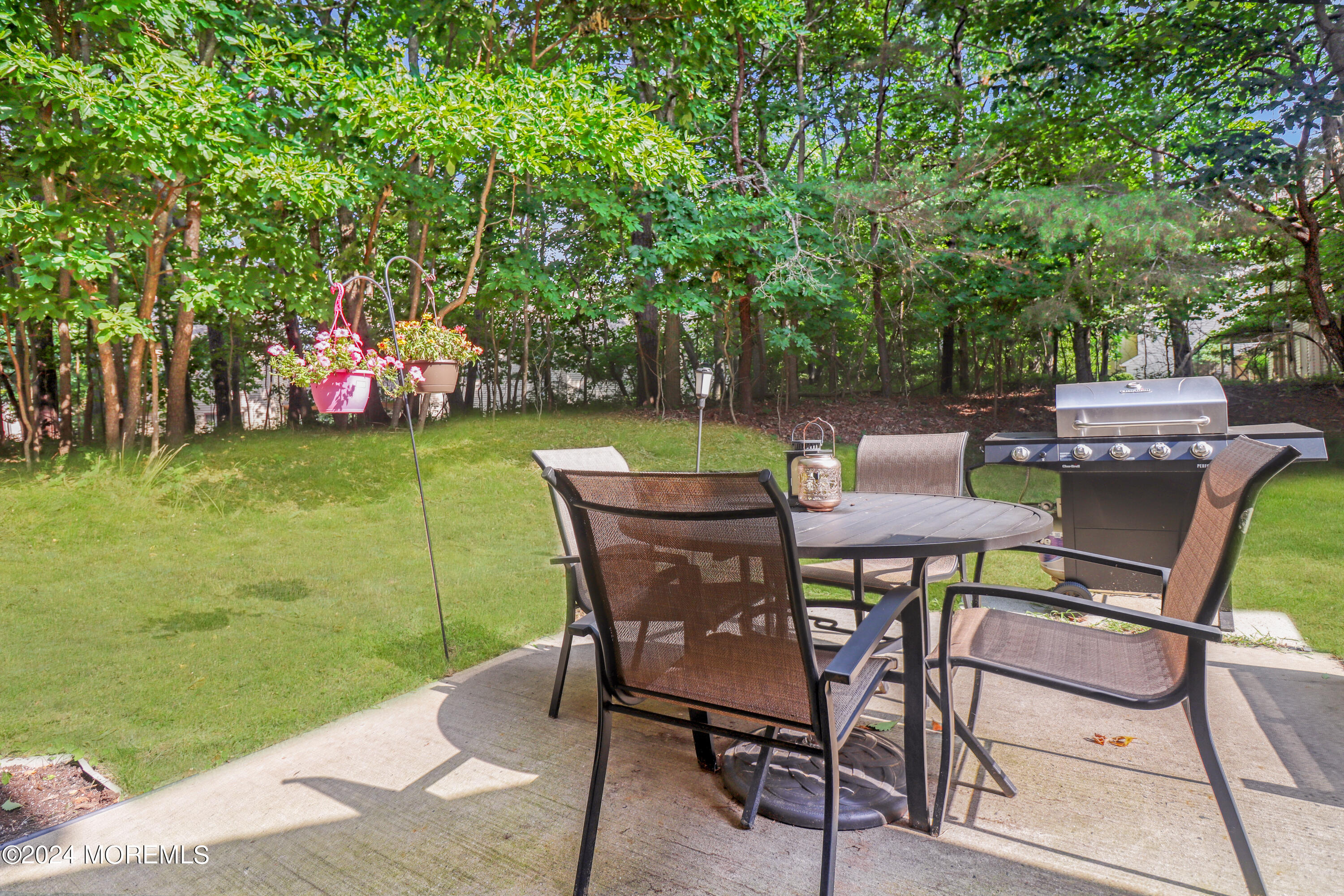 100 Whispering Oaks Way Jackson, NJ 08527 - Photo 13 of 56 a view of a chairs and table in patio next to a yard