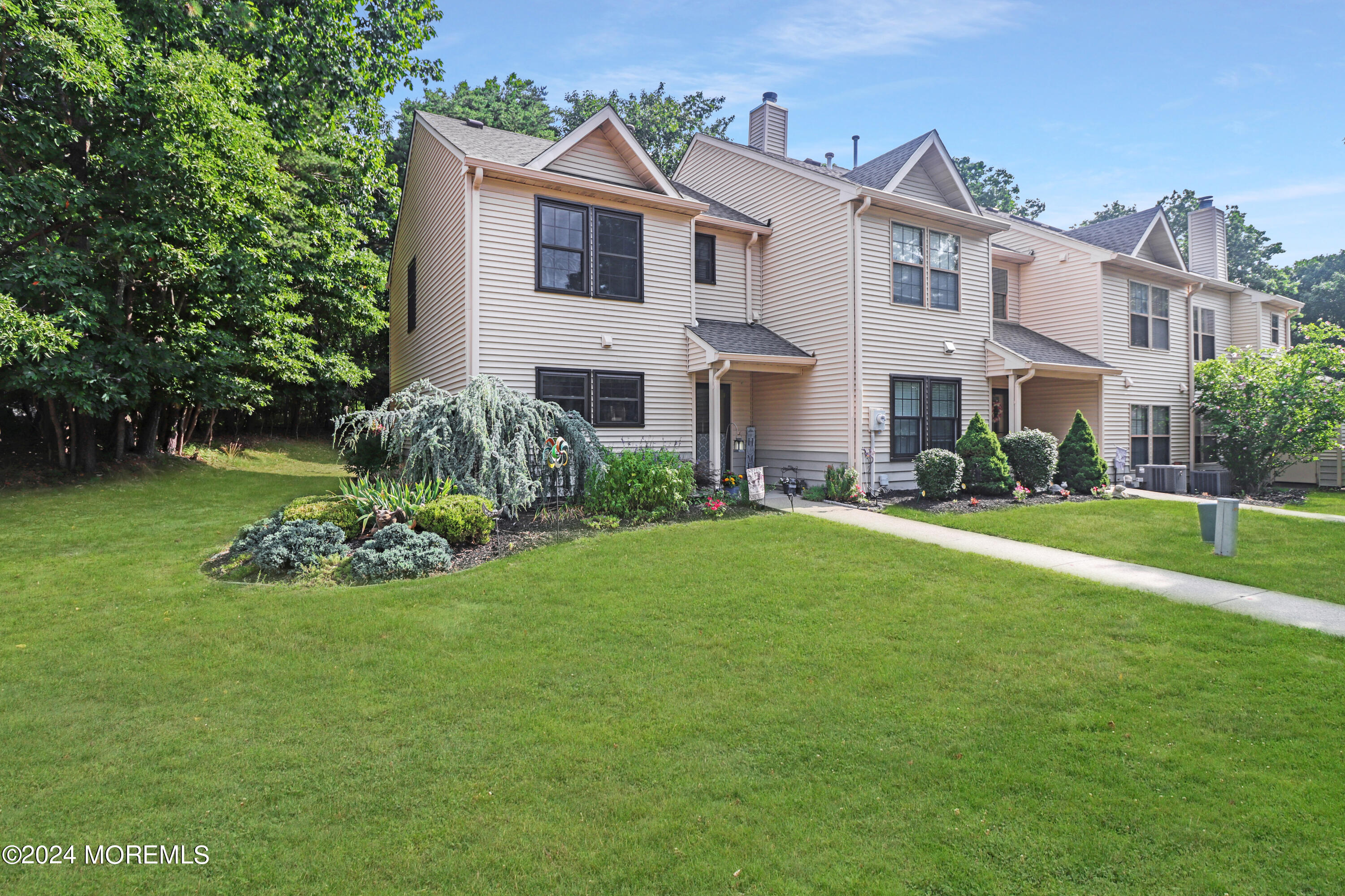 100 Whispering Oaks Way Jackson, NJ 08527 - Photo 9 of 56 a front view of a house with a garden and plants