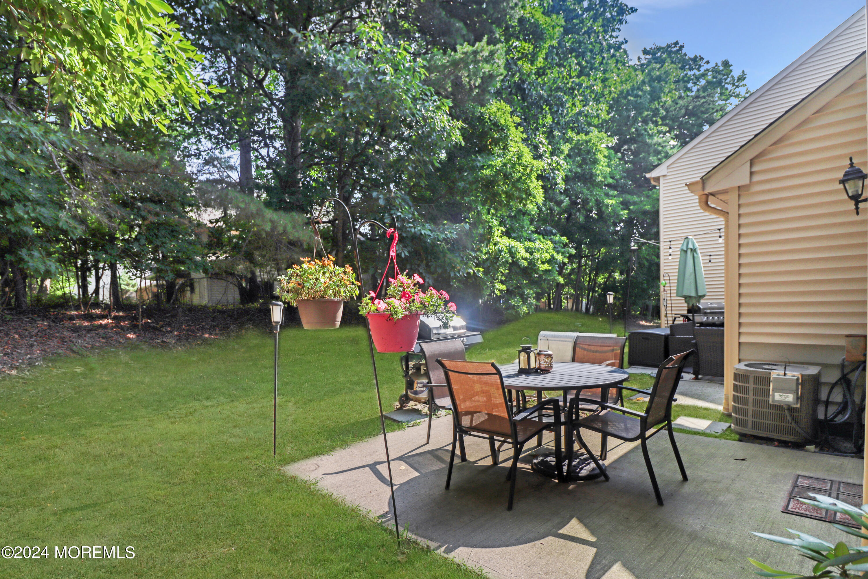 100 Whispering Oaks Way Jackson, NJ 08527 - Photo 10 of 56 a patio with table and chairs and potted plants
