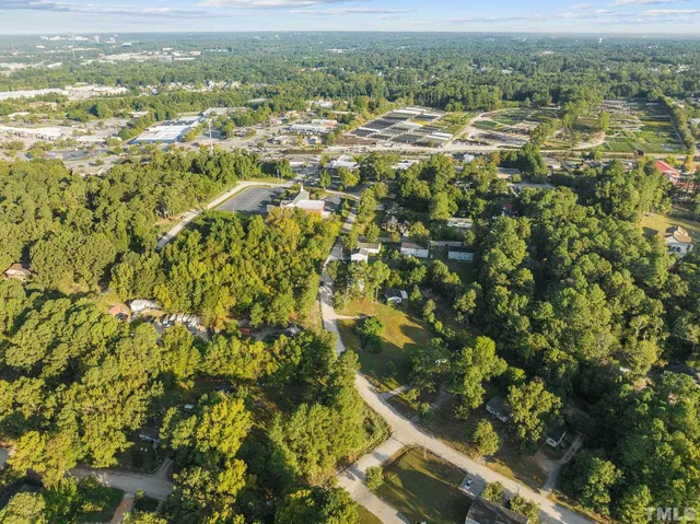 an aerial view of residential houses with outdoor space and trees