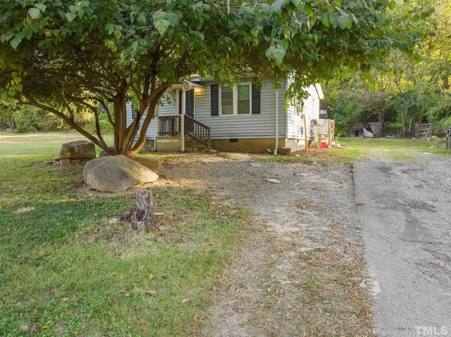 a view of a house with backyard and a tree