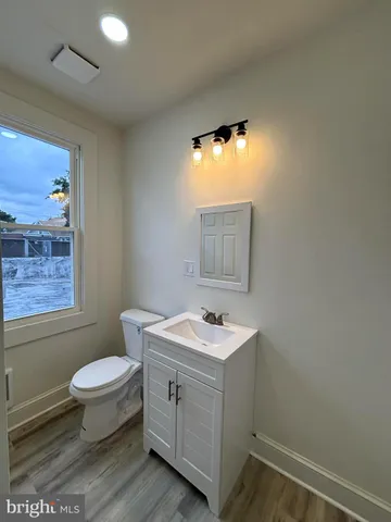 a bathroom with a granite countertop sink mirror vanity and toilet