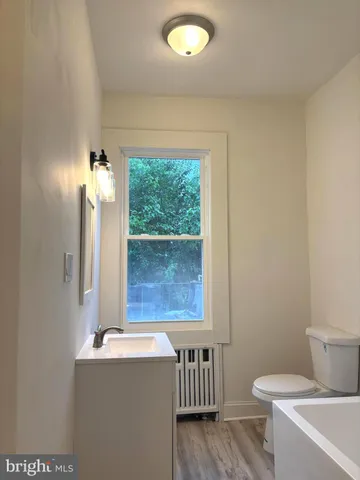 a bathroom with a toilet a sink and a window