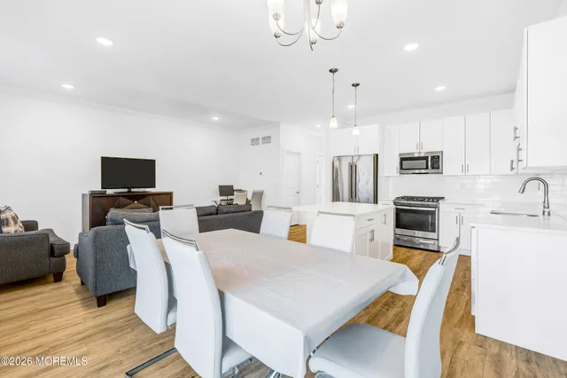 a large kitchen with kitchen island a stove a microwave a dining table and chairs