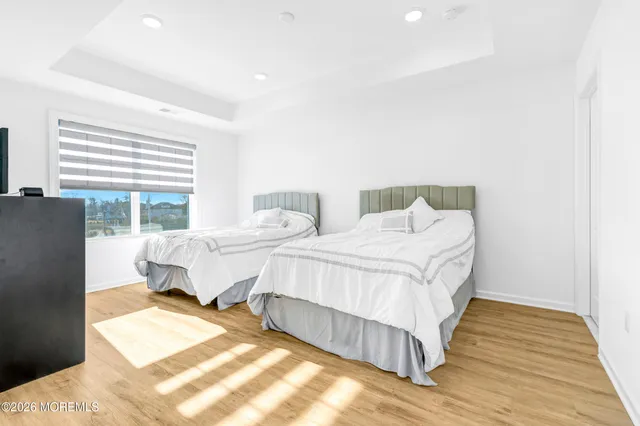 a bedroom with two beds and wooden floor