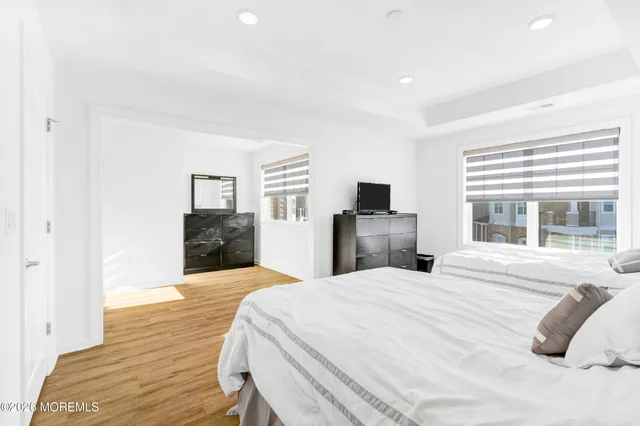 a large bedroom with a bed and wooden floor