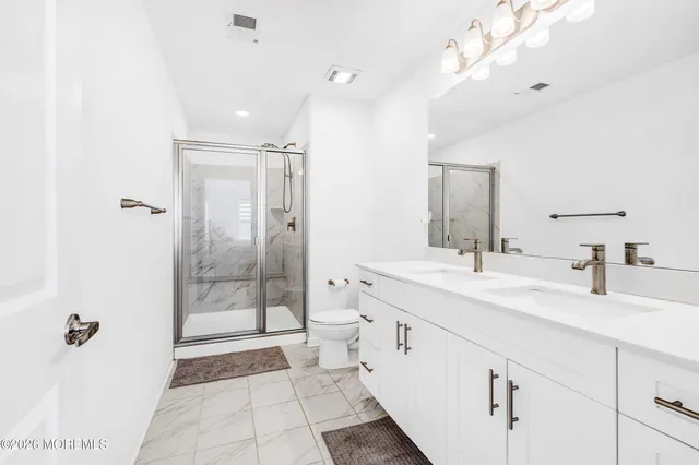 a spacious bathroom with a double vanity sink mirror and shower