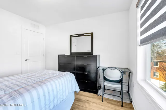 a bedroom with a chair and a window