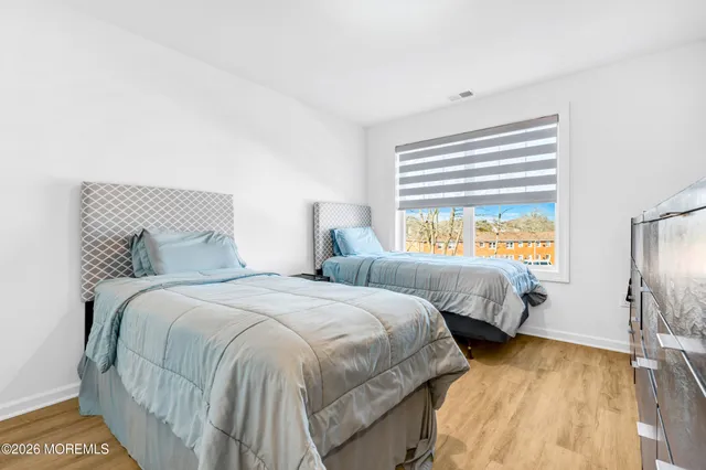 a bedroom with two beds and a dresser with mirror