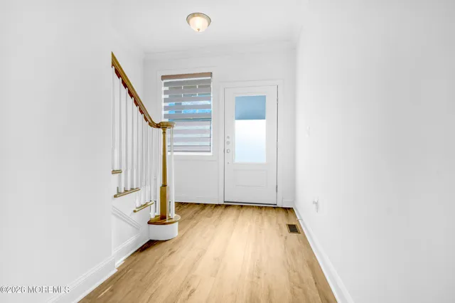 a view of a hallway with wooden floor and staircase